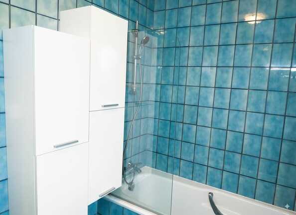 Une SDB avec une grande baignoire vitrée et de nombreux rangements