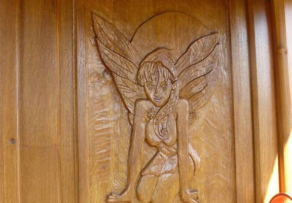La jolie fée Mélusine vous accueille sculptée au fronton de sa roulotte